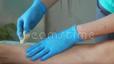将橡胶手套上的手紧贴于脱毛膏上，并通过特殊技术进行脱毛